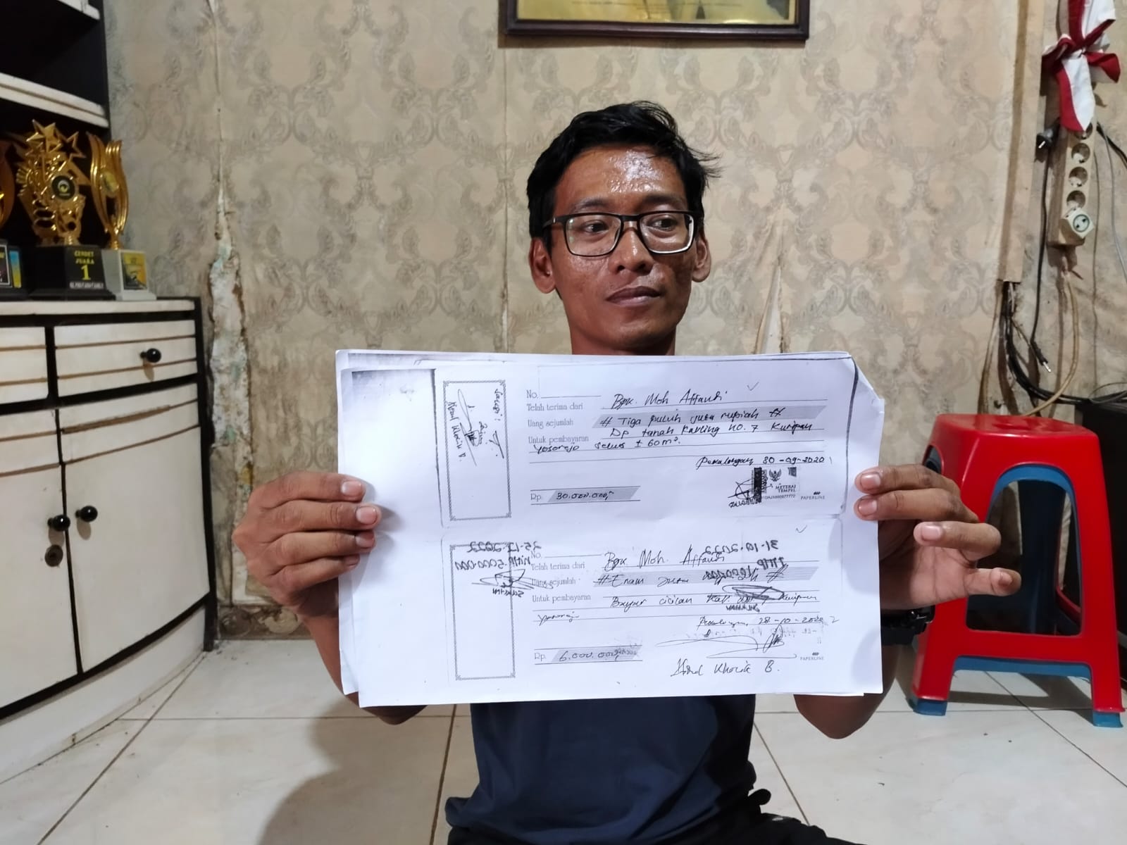TUNJUKKAN - Rifki menunjukkan bukti pembayaran tanah kavling di Kuripan gang 8. Kota Pekalongan.