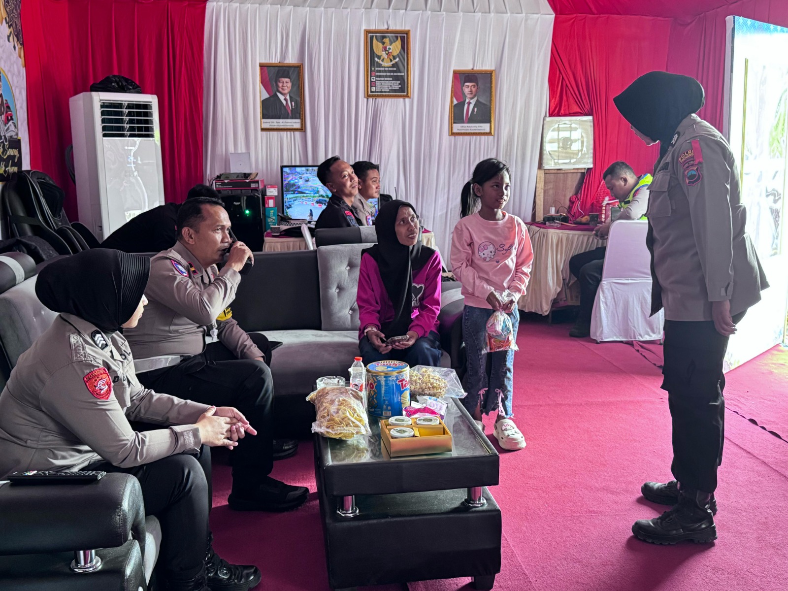TERPISAH DARI KELUARGA: Momen Yuni dan anaknya saat menghubungi pihak kepolisian di pos pengamanan mudik rest area 338 A Pekalongan gara-gara terpisah dari suaminya, Selasa (1/4/2025).