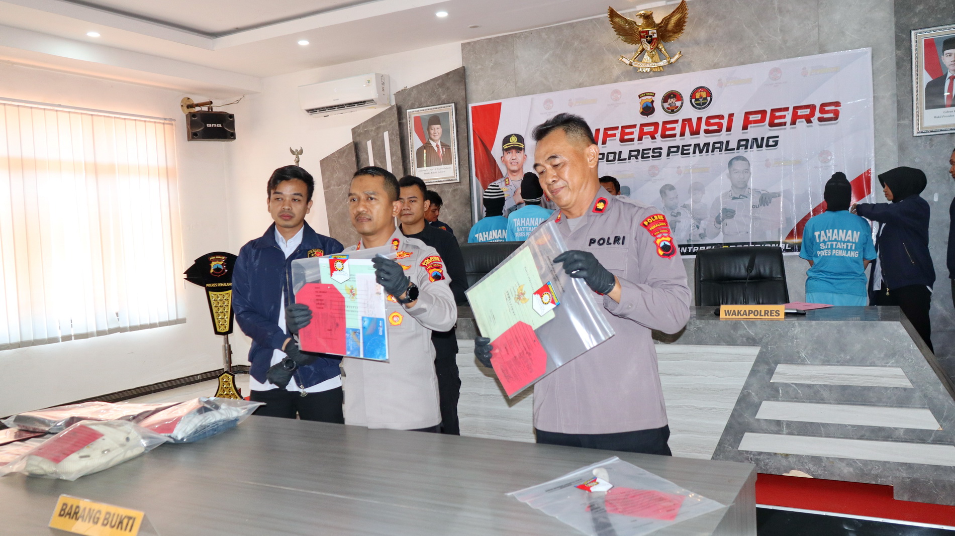 TUNJUKKAN - Kapolres Pemalang AKBP Eko Sunary, tunjukkan bukti surat anah ang dijaminkan pelaku kebank, sat konferensi pers yang digelar di Aula Tribrata Polres Pemalang pada Rabu (23/4/2025).