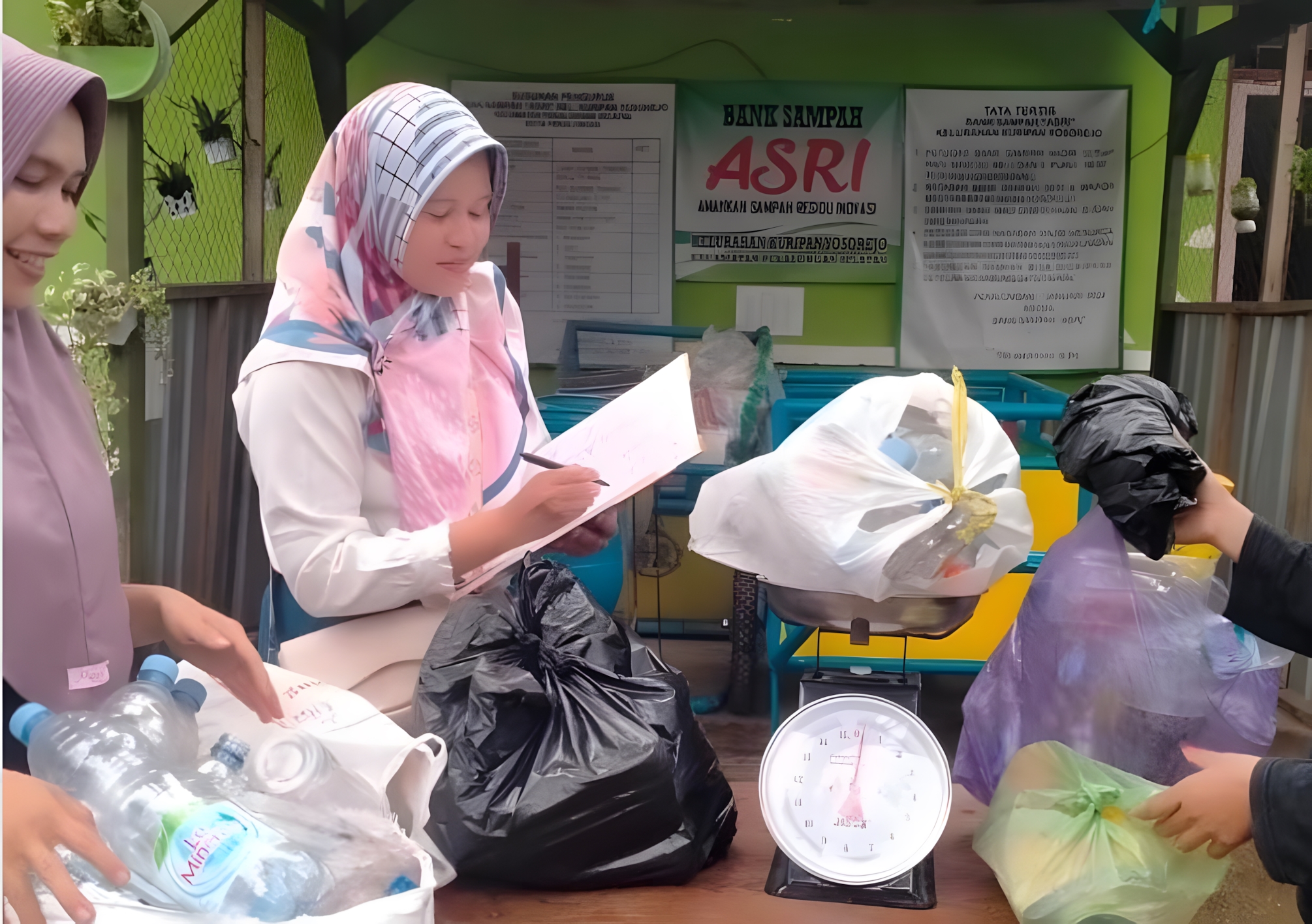 CATAT - Petugas Bank Sampah Kuryos, saat mencatat jumlah sampah kiriman warga, usai ditimbang.