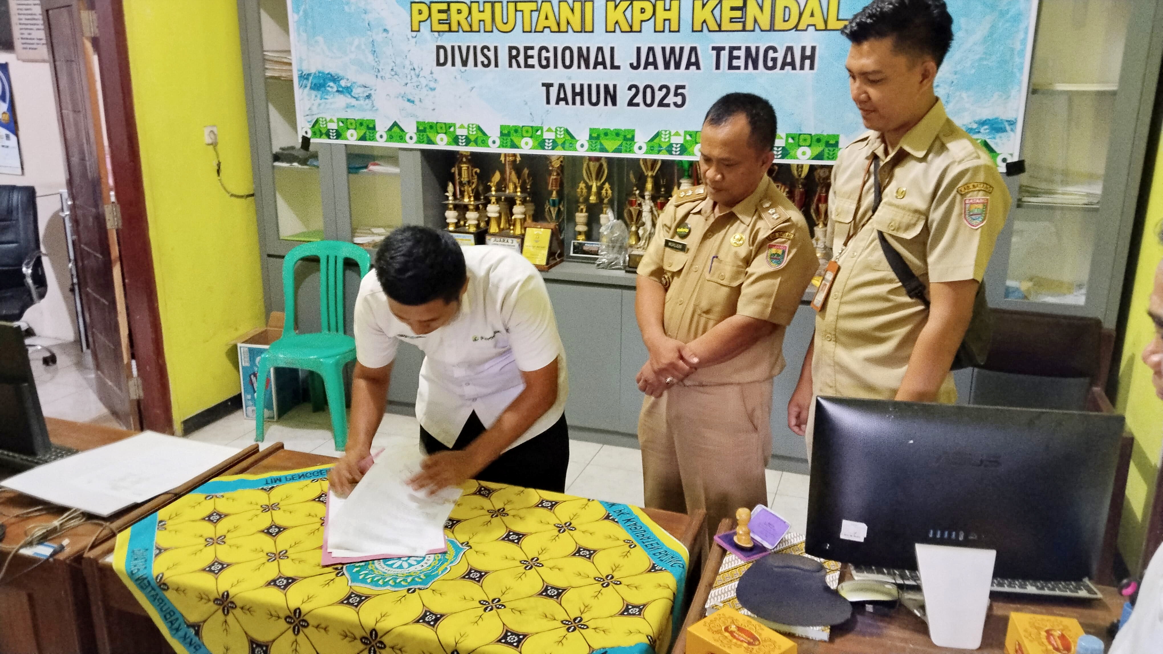 SERAHKAN - Perwakilan Perum Perhutani KPH Kendal saat serahkan bantuan kepada Pemdes Suradadi Gringsing, Senin (19/5/2025).