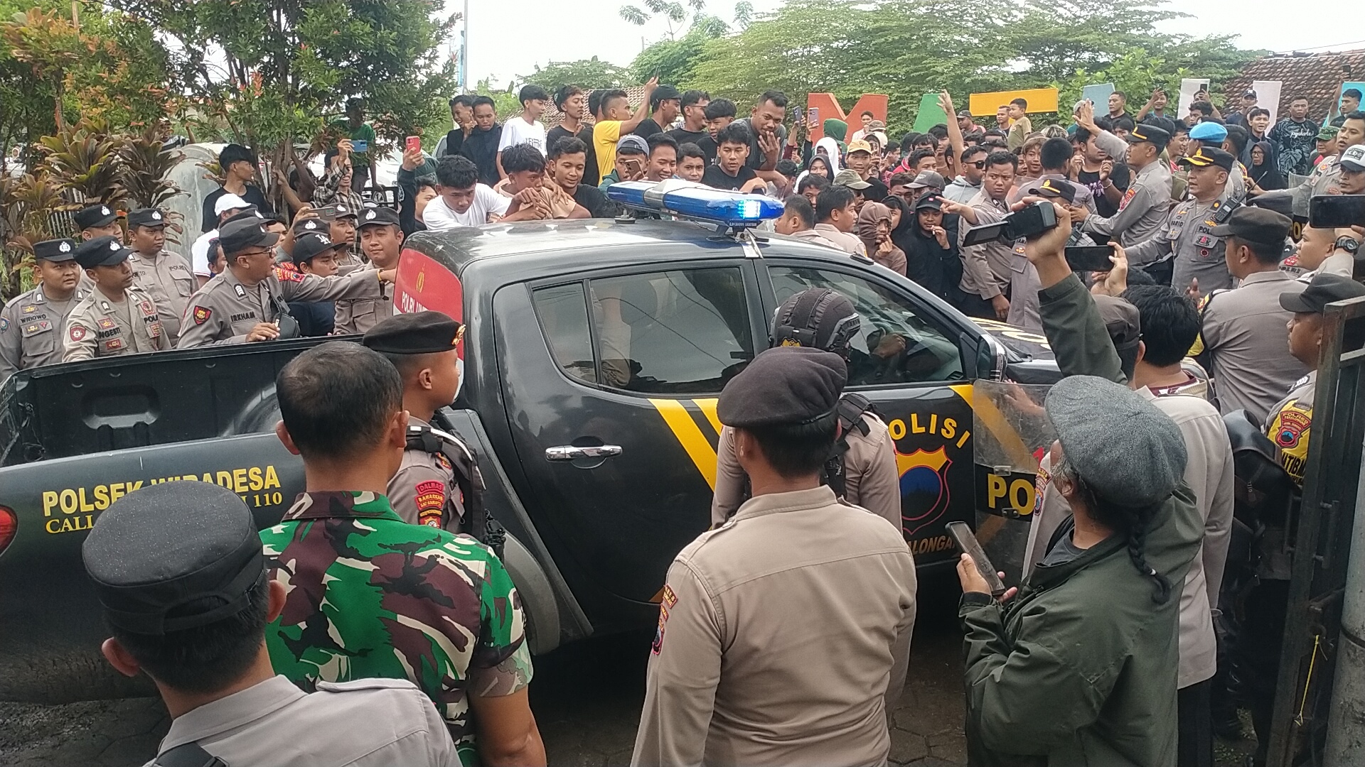 GERUDUK BALAI DESA: Suasana demonstrasi warga Desa Sijambe, Wonokerto Kabupaten Pekalongan. Warga mencoba menerobos barikade ketika Eko Rizal dievakuasi menggunakan mobil polisi, Jumat (23/5/2025).
