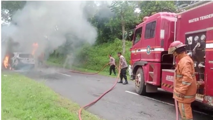 MOBIL TERBAKAR: Polisi dan petugas damkar saat turun ke lokasi mobil terbakar di jalur arah objek wisata Linggoasri, Minggu (25/5/2025).