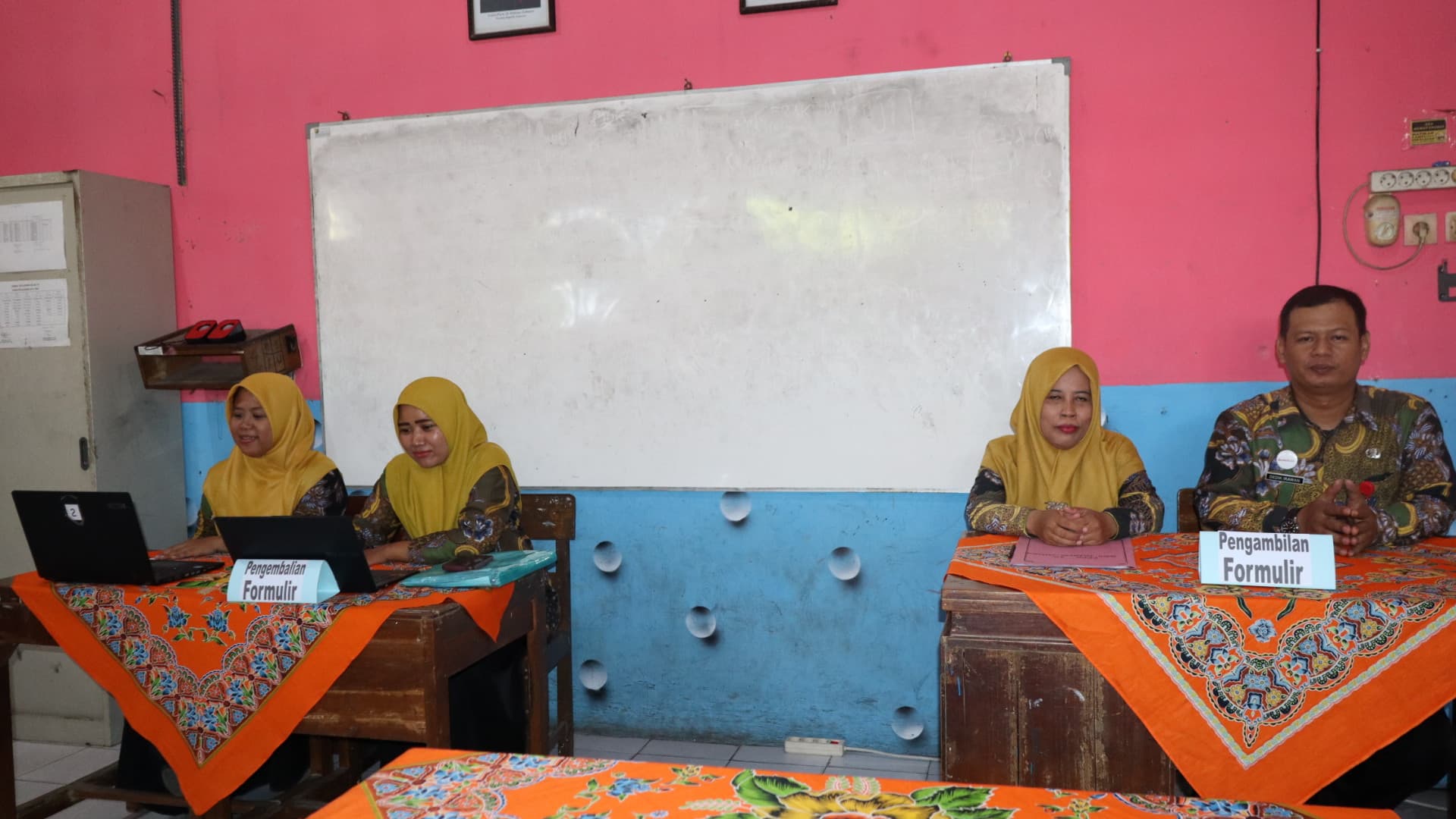 SIAGA - Tim Sistem Penerimaan Murid Baru SDN Sapuro 5 saat berjaga di ruang penerimaan siswa baru, pada Kamis (12/6/2025).