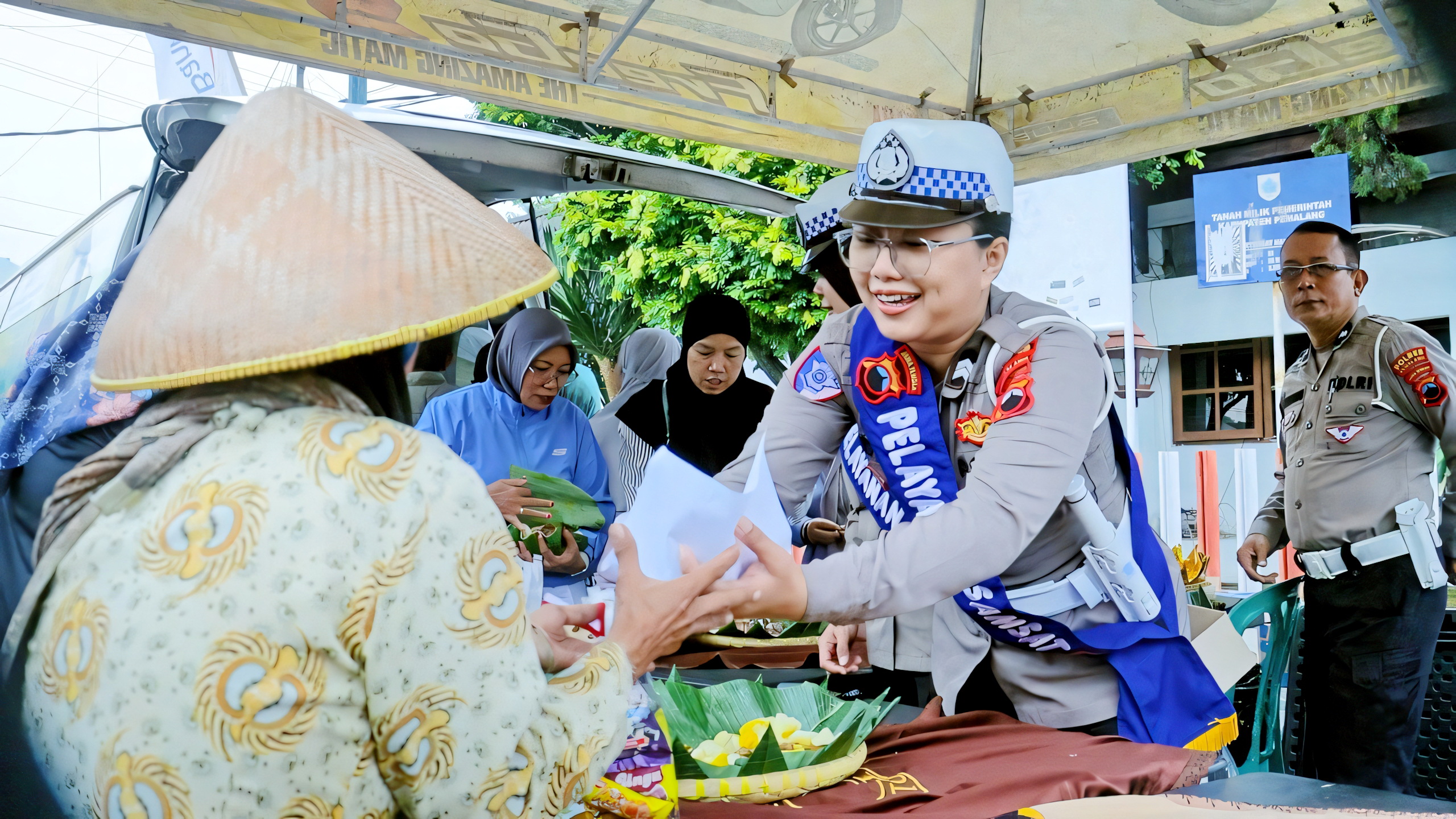 LAYANAN - Anggota Polres Pemalang saat berikan jajanan gratis kepada warga Pekalongan yang menikmati CFD setempat, Minggu (22/6/2025).