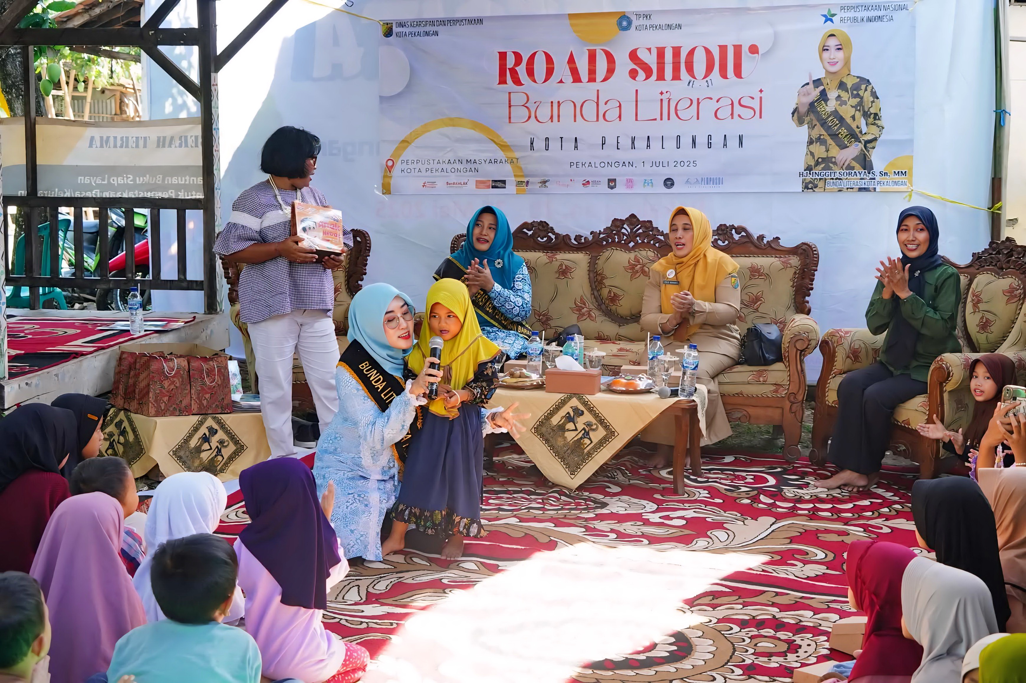 AJAK NGOBROL - Bunda Literasi Kota Pekalongan Inggit Soraya, saat ngobrol dengan salah satu anak warga Pringrejo yang suka membaca di TBM, Ceria di Kelurahan Pringrejo, Selasa sore (1/7/2025).