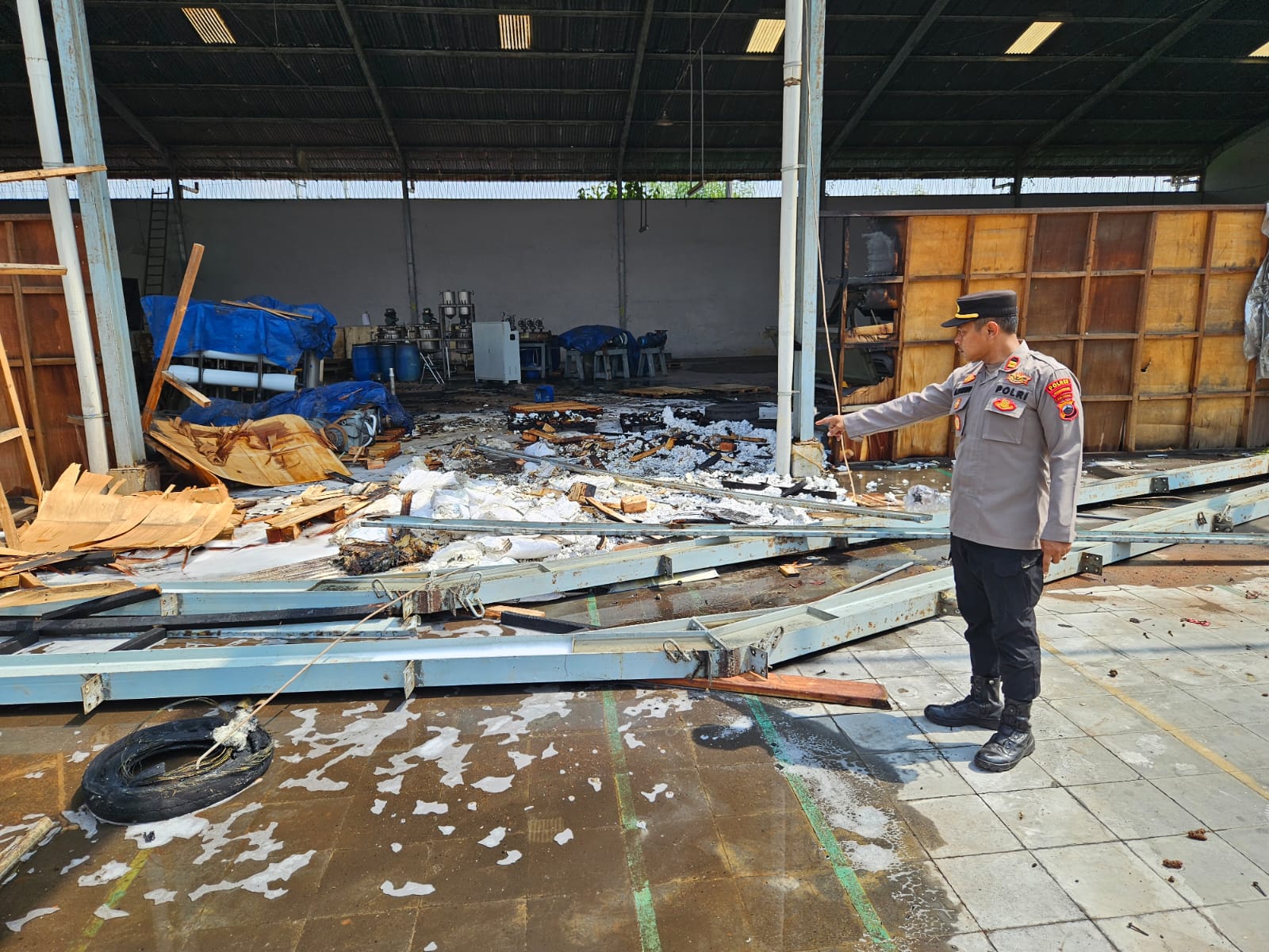 TERBAKAR: Kapolsek Wiradesa Iptu Maman Sugiharto menunjuk lokasi kebakaran setelah kobaran berhasil dipadamkan petugas damkar, Senin (7/7/2025).