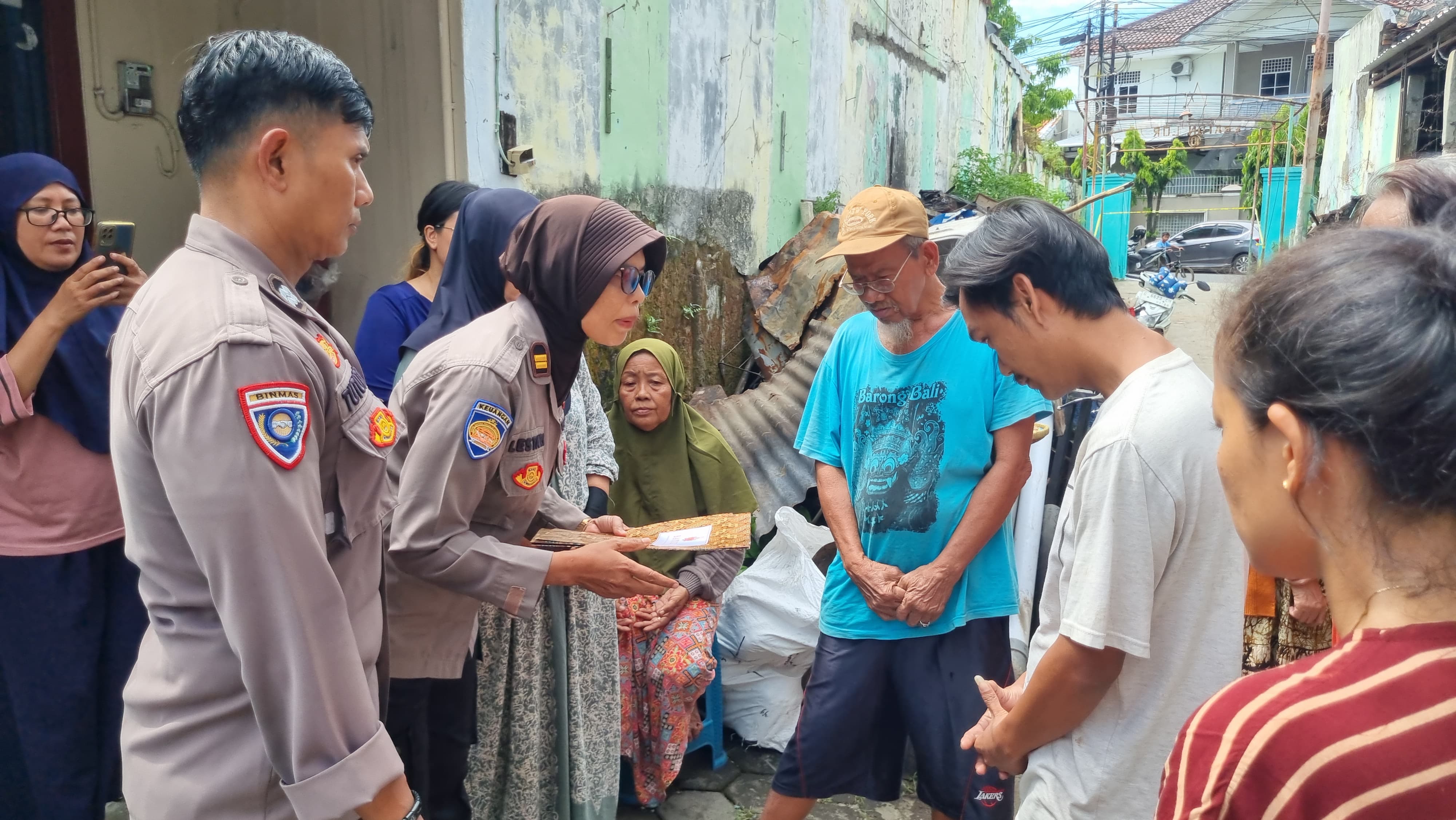 SERAHKAN BANTUAN - Perwakilan Polres Pekalongan Kota saat serahkan bantuan kepada korban kebakaran, di Padukuhan Kraton Pekalongan Utara, Selasa (8/7/2025).