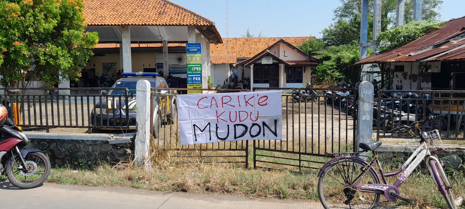 PROTES: Spanduk protes warga yang dipasang di pagar Balai Desa Sijambe ketika audiensi berlangsung, Jumat (11/7/2025).