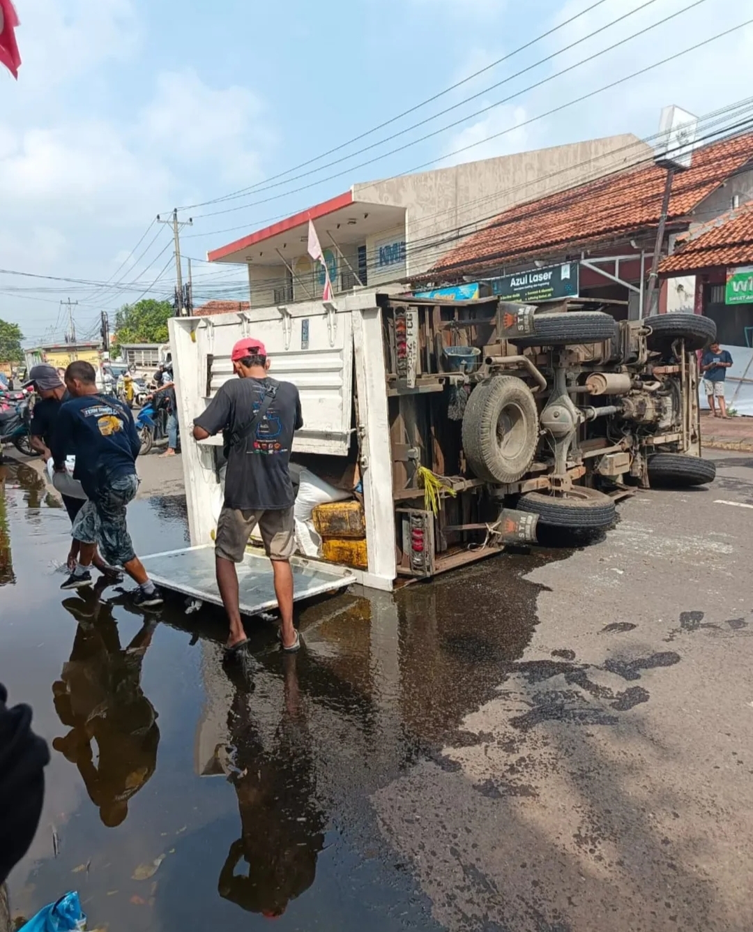 TERGULING: Truk boks bermuatan minyak goreng terguling di Jalan Mayjend Sutoyo, Gumawang, Wiradesa, Kabupaten Pekalongan, Senin (14/7/2025).