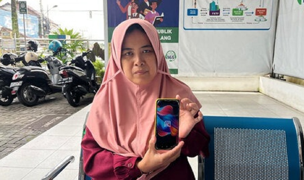 Annisa Fitriani menunjukkan aplikasi Mobile JKN.