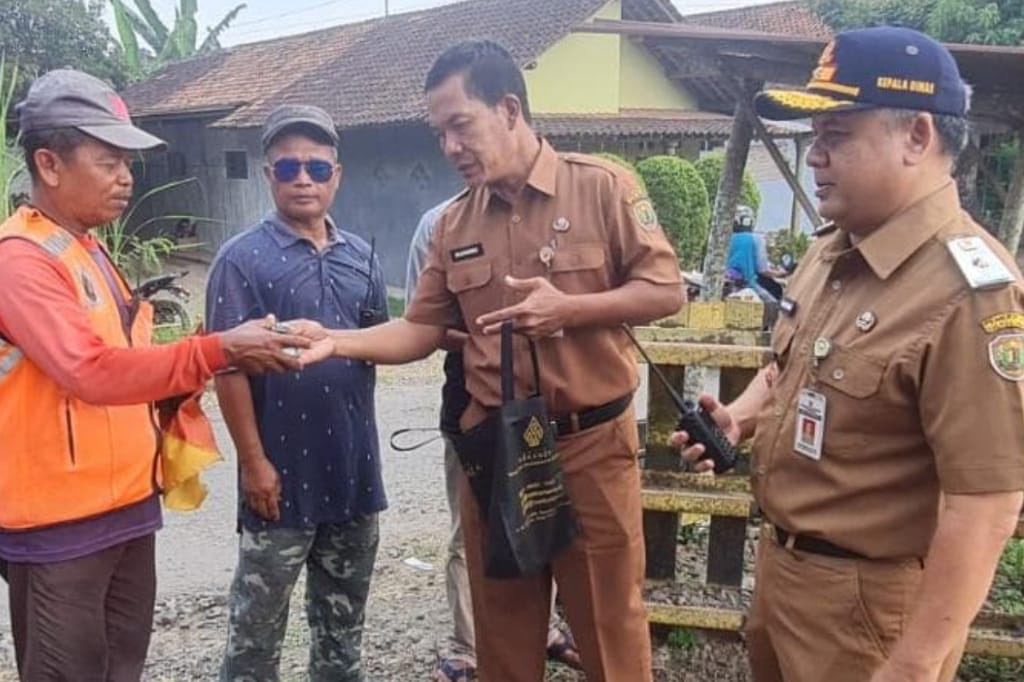 TRANSPORTASI: Dishub Kabupaten Pekalongan saat menyerahkan HT kepada penjaga palang perlintasan kereta api.