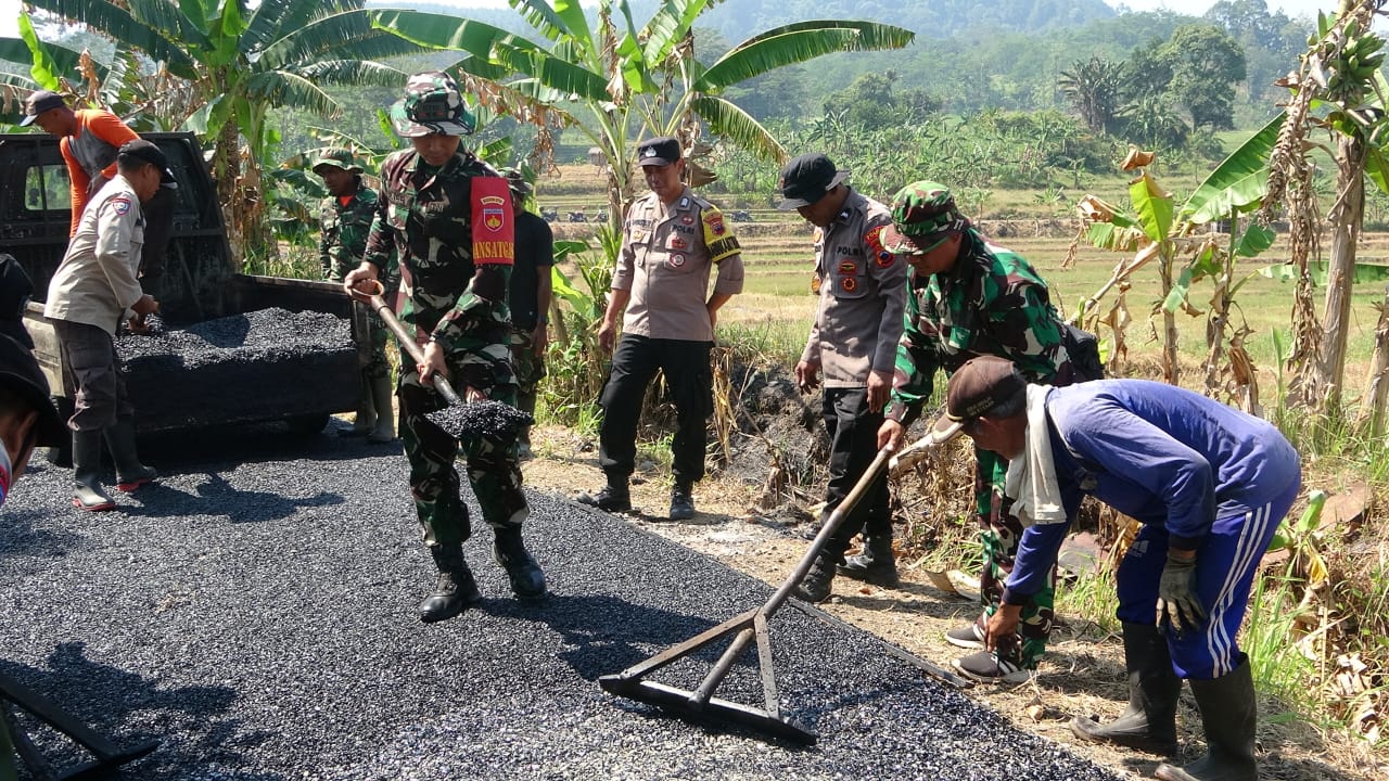 TMMD: Dandim 0710/Pekalongan Letkol Arm Ihalauw Garry Herlambang saat ikut berjibaku dalam proses pengaspalan jalan Desa Windurojo, Kecamatan Kesesi, Kabupaten Pekalongan, Minggu (3/8/2025).