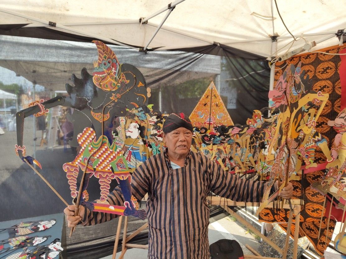 KREATIF: Kusnan Riyanto saat menunjukkan wayang-wayang buatannya.