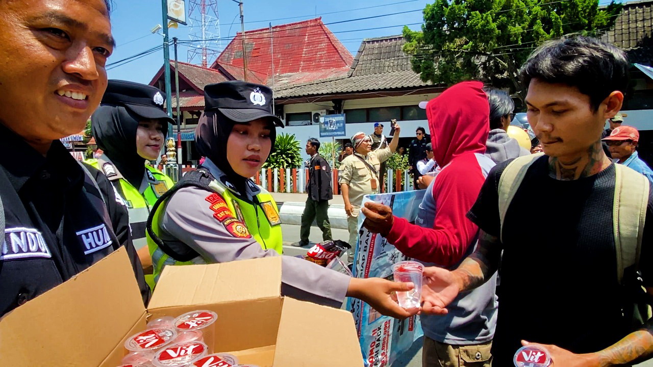BERBAGI - Anggota Polres Pemalang saat bagikan minuman gratis pada aksi damai di Halaman Pemda Pemalang, Kamis (4/9/2025).