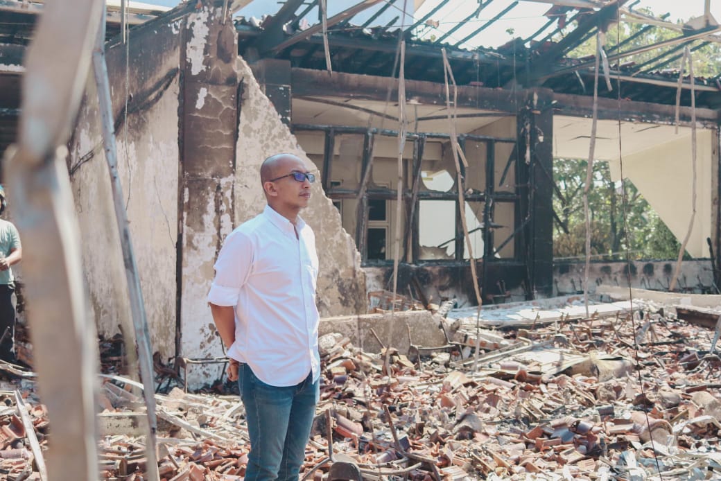 MENATAP -  Ketua DPRD Kota Pekalongan, M. Azmi Basyir, menatap dengan sedih kondisi kantornya yang luluh lantak dihancurkan perusuh.