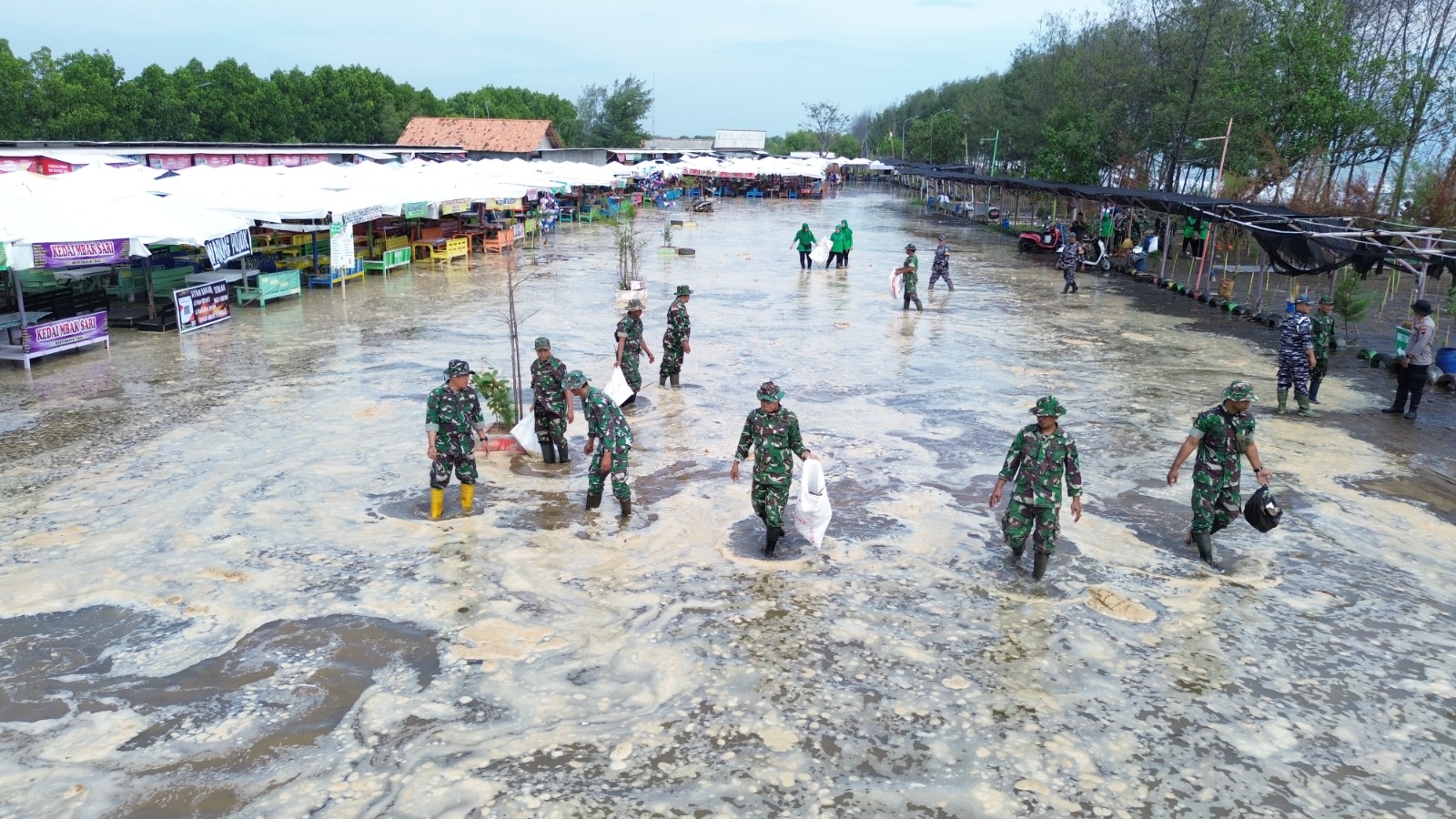 GOTONG ROYONG: Koramil 10/Wiradesa bersama masyarakat saat bersih-bersih objek wisata Pantai Wonokerto, Kabupaten Pekalongan, Sabtu (20/9/2025).
