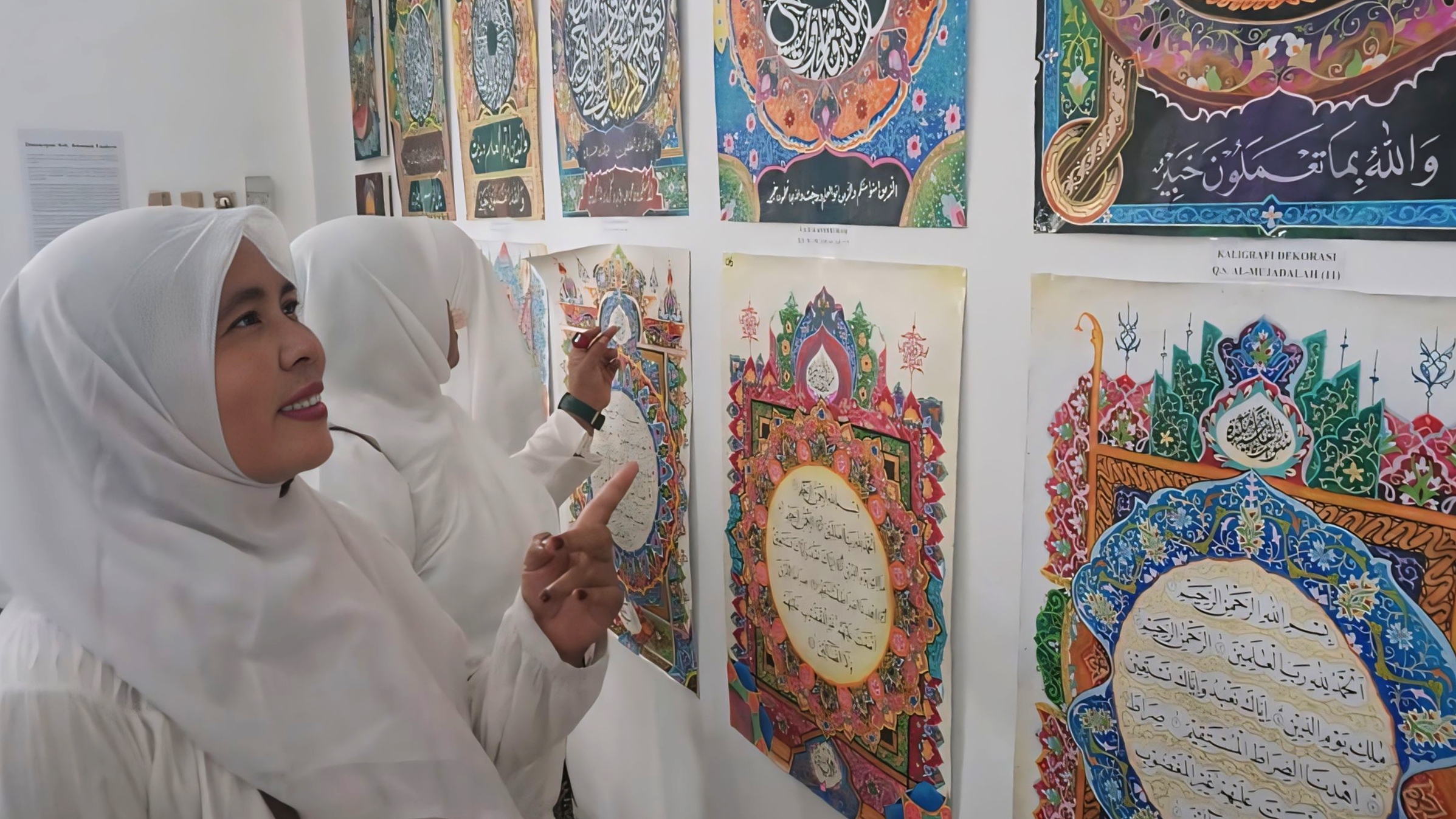 KAGUMI - Salah satu pengunjung pameran Turats Aswaja saat mengagumi karya kaligrafi, di Gedung Aswaja Kota Pekalongan.