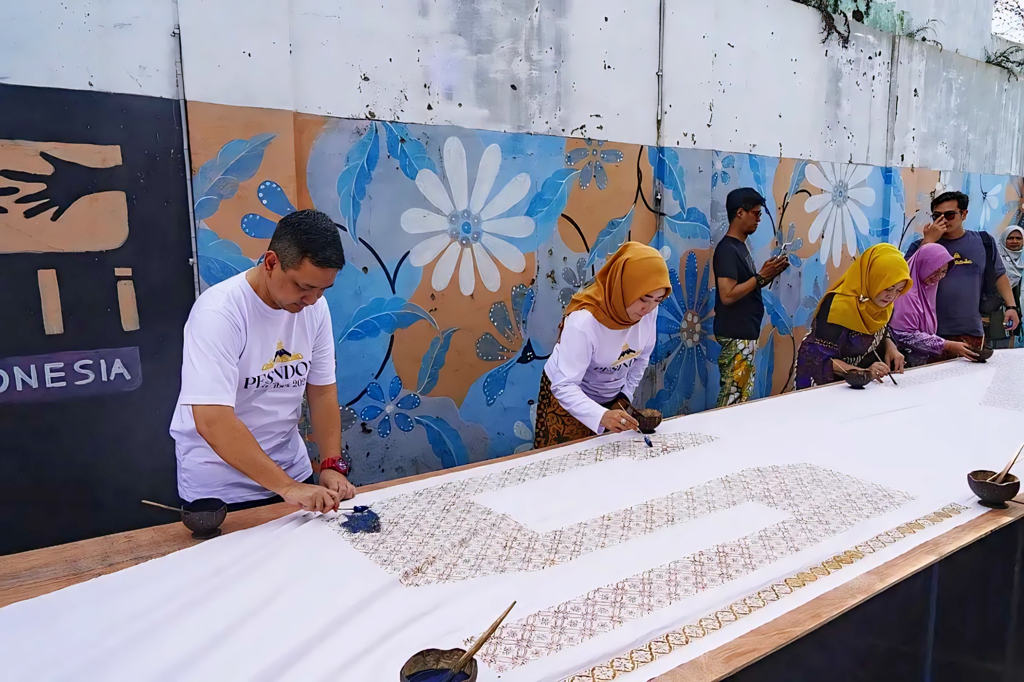 MENCAP BATIK - WaliKota HA Afzan Arslan Djunaid dan Ketua TP PKK Kota Pekalongan Inggit Soraya saat ikut mencap batik di kain panjang 116 meter di Kampung Batik Pesindon, Sabtu (25/10/2025).