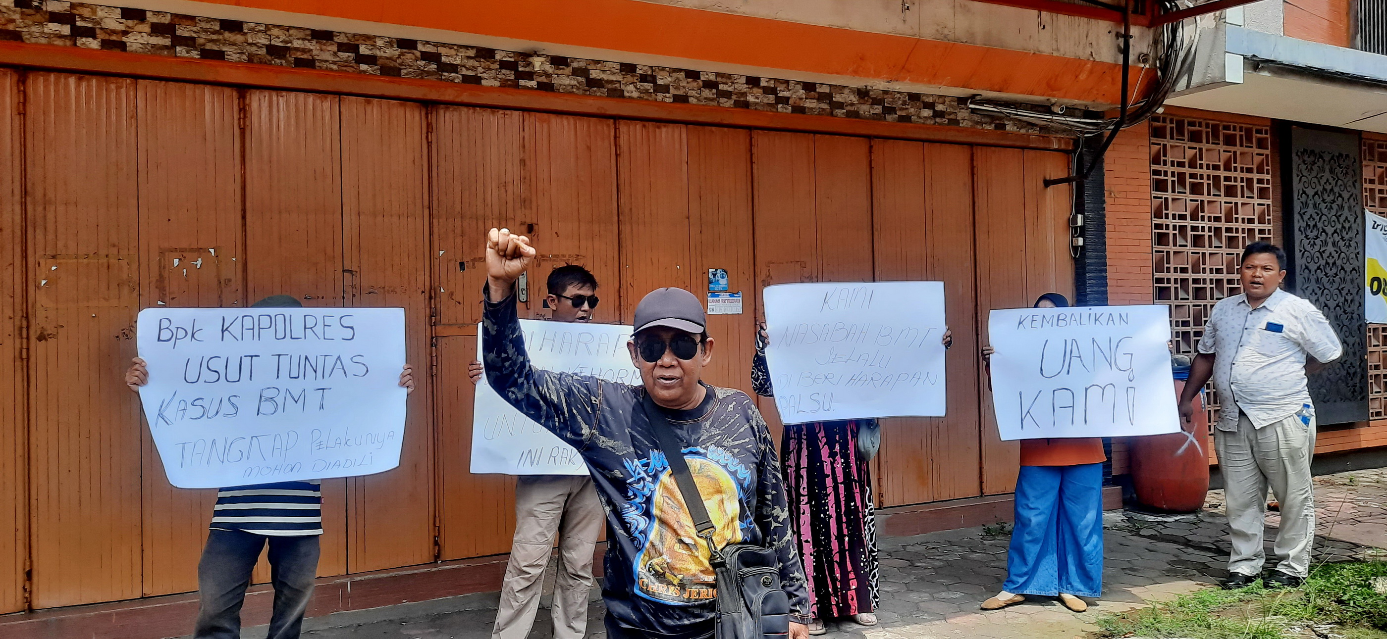 AKSI DAMAI - Sejumlah korban BMT Umat,saat aksi damai di depan kantor&nbsp;pusat, menuntut kejelasan nasib&nbsp;uang mereka, Senin (27/10/2025).