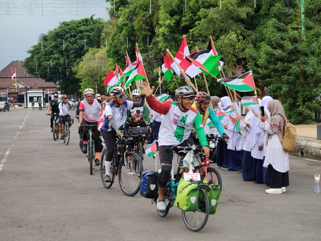 SOLIDARITAS: Para pesepeda saat memberikan dukungan untuk Palestina melintasi Kabupaten Batang.