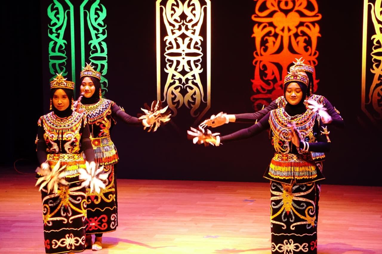 Tarian Dayak perempuan tampil memukau dengan atribut bulu dan riasan tradisional yang mencerminkan identitas budaya Kalimantan.