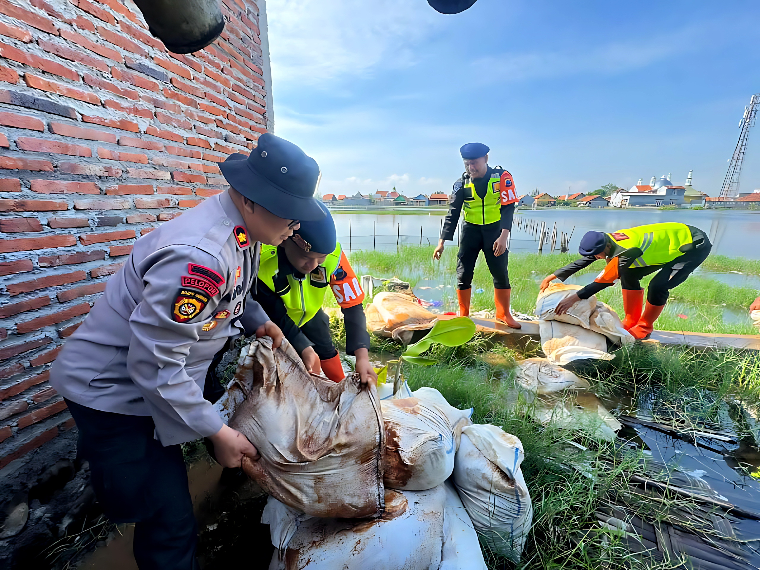 BUAT TANGGUL - Anggota Polres Pekalongan Kota, bersama anggota Brimob&nbsp;TNI dan masyarakat saat membuat tanggul darurat di Bandengan.
