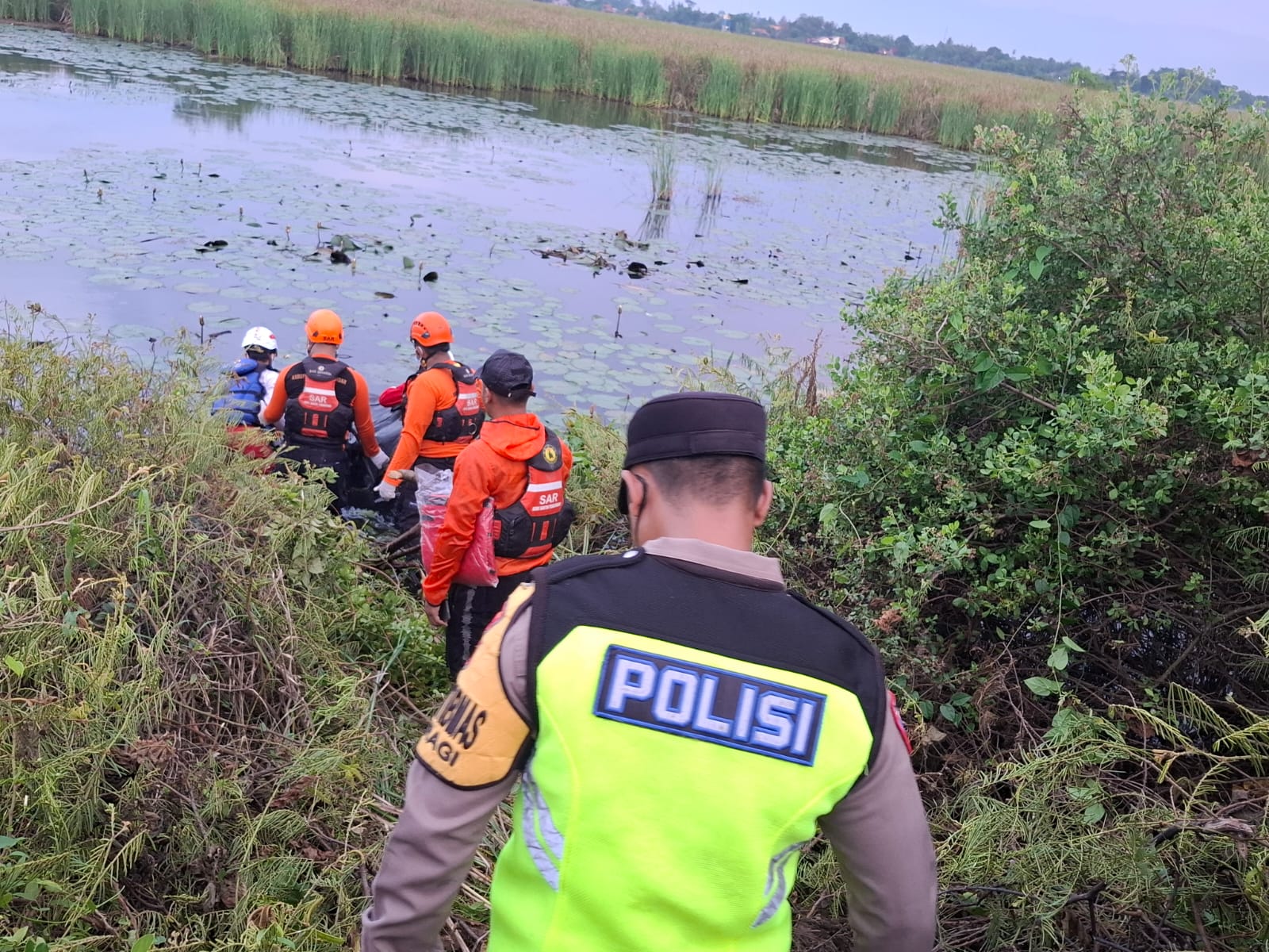 EVAKUASI: Polisi dan relawan saat akan mengevakuasi mayat di rawa bekas persawahan, Desa Yosorejo, Kecamatan Siwalan, Kabupaten Pekalongan, Sabtu (6/12/2025).
