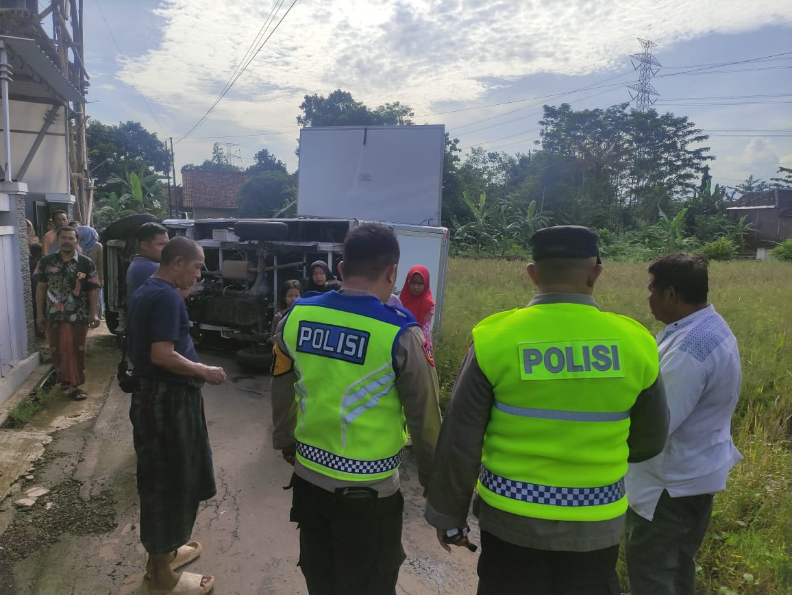 TERGULING: Mobil atau armada pengangkut MBG terguling usai tabrak pagar rumah warga di Jalan Raya Pakisputih, Kecamatan Kedungwuni, Kabupaten Pekalongan, Jumat (12/12/2025).