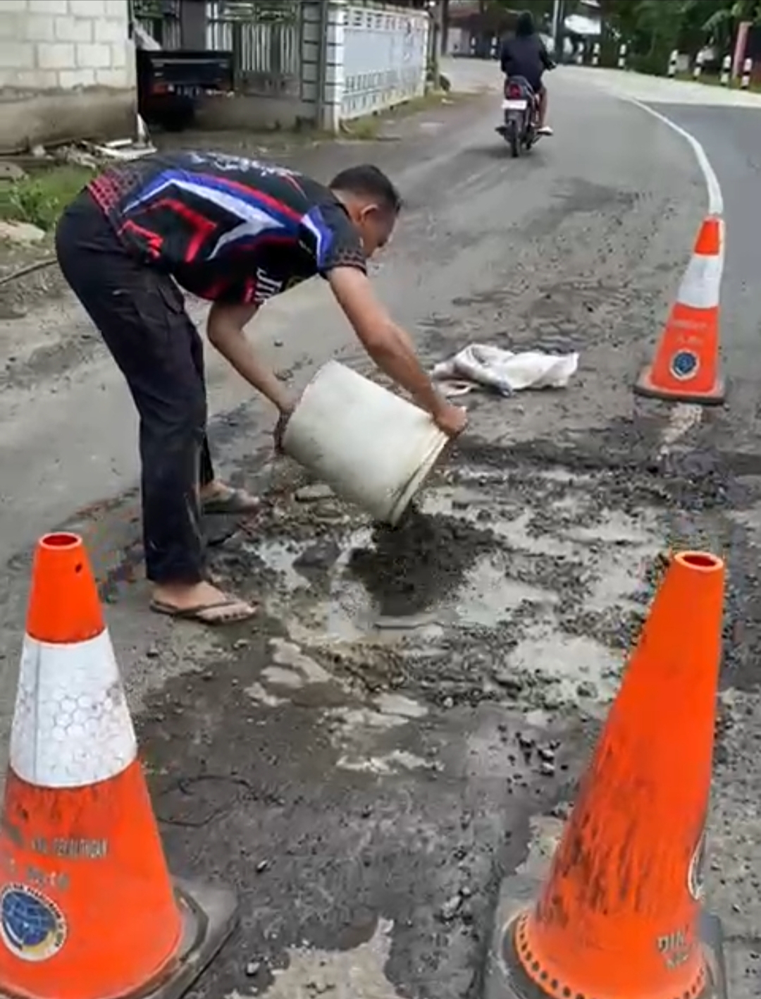 TUAI PUJIAN: Aksi Briptu Muhammad Faiq Thufail, anggota Satlantas Polres Pekalongan, saat menambal lubang jalan di Jalan Raya Wiradesa.