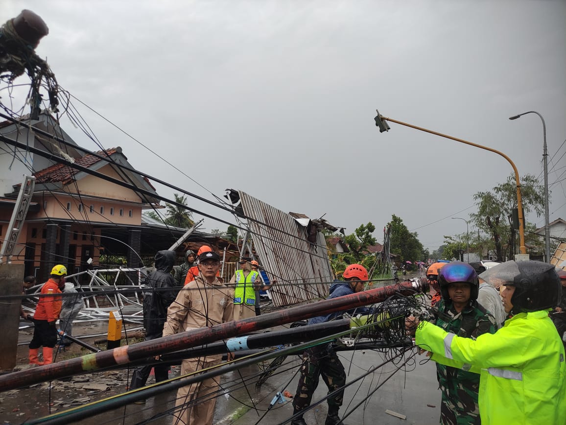 EVAKUASI: Petugas kepolisian, BPBD, PLN, dan relawan saat berjibaku mengevakuasi pohon maupun tiang listrik roboh.