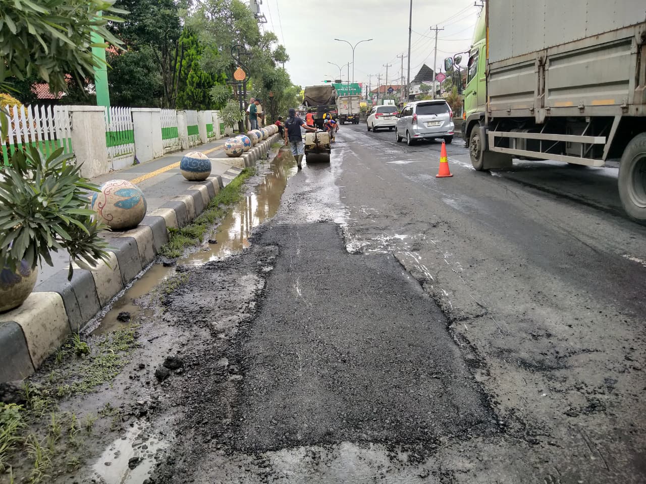 JALAN BERLUBANG: Petugas saat melakukan penambalan jalan Pantura Batang.
