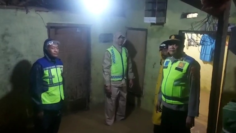 GENANGAN: Kapolsek Kedungwuni meninjau salah satu rumah warga yang tergenang.