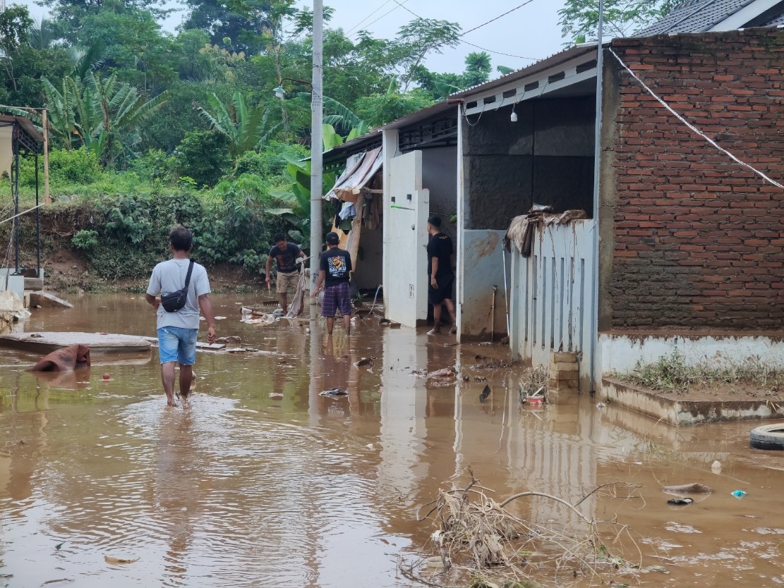 BANJIR: Warga saat membersihkan material lumpur yang terbawa saat banjir datang.