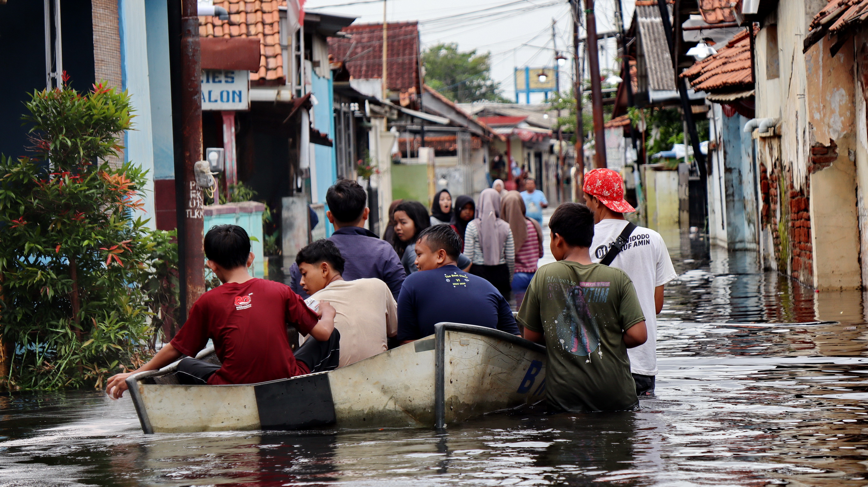 TRANSPORTASI - Warga gang 1 Tirto Kelurahan Tirto gunakan perahu untuk aktifitas menuju rumahnya, karena seluruh wilayahnya terendam banjir, Rabu (21/1/2026).