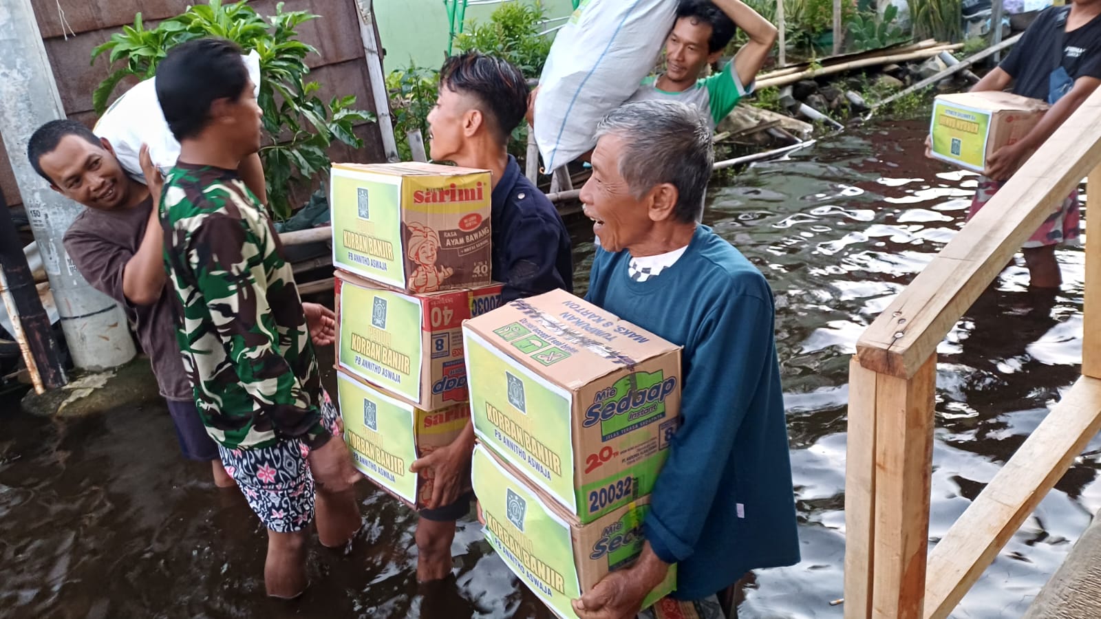 TERIMA BANTUAN : Warga terdampak banjir di Pasir Sari, Kecamatan Pekalongan Barat, menerima bantuan sembako dari Annitho Aswaja.