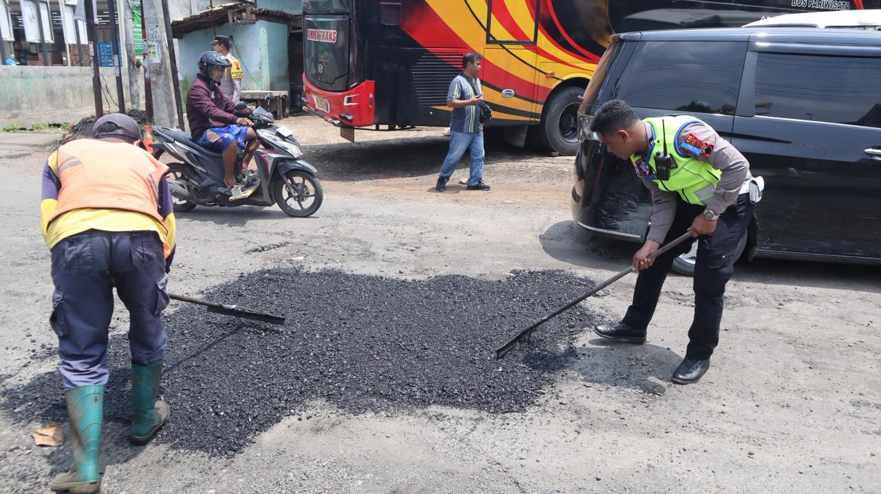 KOLABORASI: Balai Pengelolaan Jalan bersama kepolisian menambal lubang jalan di Bojong,  ruas Wiradesa-Kajen, Kabupaten Pekalongan, Selasa (3/2/2026).