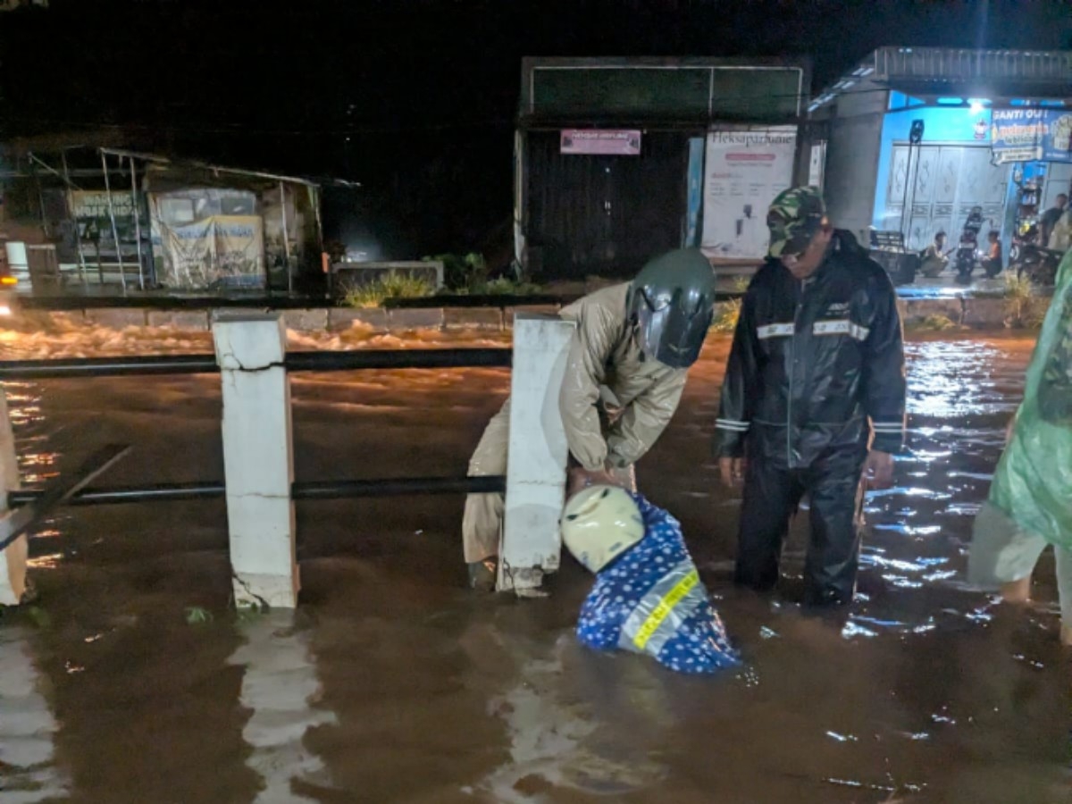 BANJIR: Petugas saat membersihkan saluran drainase di Pantura Subah yang tergenang banjir.