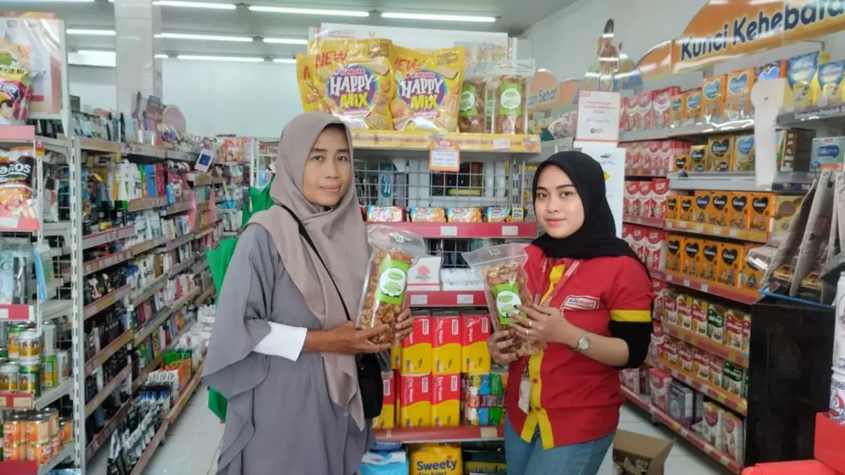 PASARKAN : Pemilik usaha Kripik Ricco Pekalongan Furaroh, saat serahkansecara simbolis produknya ke pegawai Alfamart untuk dipasarkan. (LUTFI HANAFI/JAWA POS METRO PEKALONGAN)