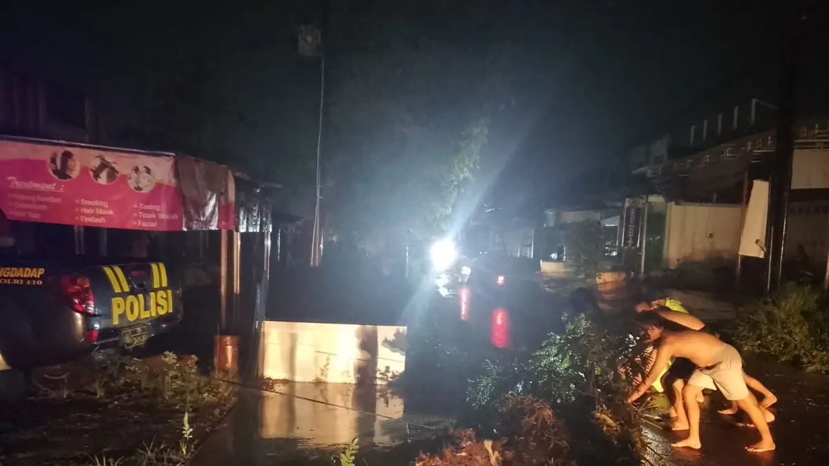 EVAKUASI: Warga dan petugas kepolisian saat mengevakuasi pohon tumbang di jalan raya Karangdadap, Kabupaten Pekalongan, Rabu 29 April 2026. (DOK. POLRES PEKALONGAN)