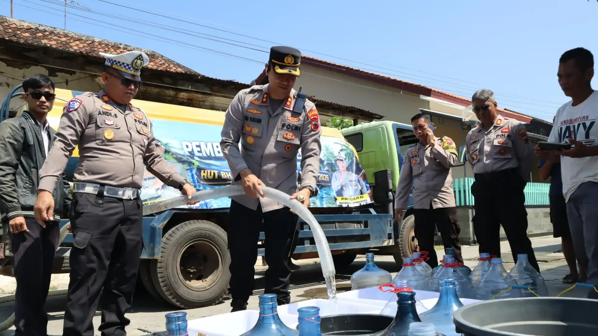BAGI AIR - Polisi saat bagi air di wilayah pesisir di Kota Pekalongan yang mulai kekurangan air bersih, untuk itu warga diminta bijak gunakan air.(IST)