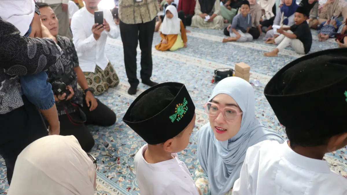 BERCENGKRAMA : Ketua TP PKK Kota Pekalongan Inggit Soraya saat bercengkrama dengan salah satu anak penerima santunan di &nbsp;Masjid Al-Ikhlas, Kamis (9/7/2026).(Lutfi Hanafi/Jawa Pos Metro Pekalongan).
