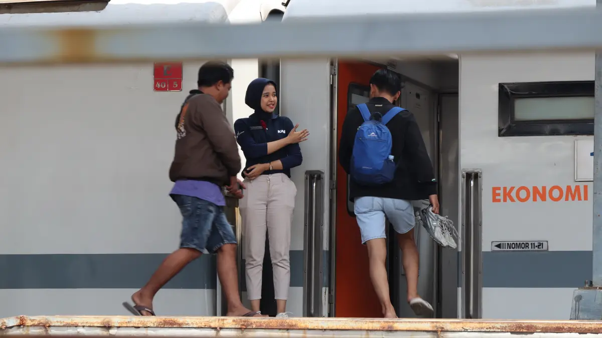 PERSILAHKAN : Dengan ramah petugas saat mempersilahkan penumpang masuk kedalam gerbong sebelum kereta berjalan di Stasiun Pekalongan baru-baru ini.(Lutfi Hanafi/Jawa Pos Metro Pekalogan)