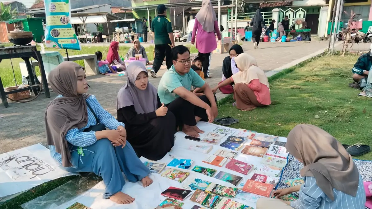 CINTAI BUKU : Komunitas Taman Baca Masyarakat (TBM) Wiradesa mengajak anak anak di Kabupaten Pekalongan untuk mencintai buku dengan lesehan di pinggiran Lapangan Kemplong, Wiradesa, Kabupaten Pekalongan. (MAULIDA USNA AULIA/JAWA POS METRO PEKALONGAN)