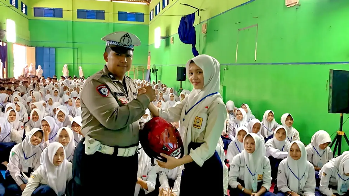 HADIAH HELM : Salah satu siswi yang bisa menjawab pertanyaan seputar aturan lalulintas dapat gratis helm saat MPLS, dari Polres Pemalang, Kamis (16/7/2026).(ist)
