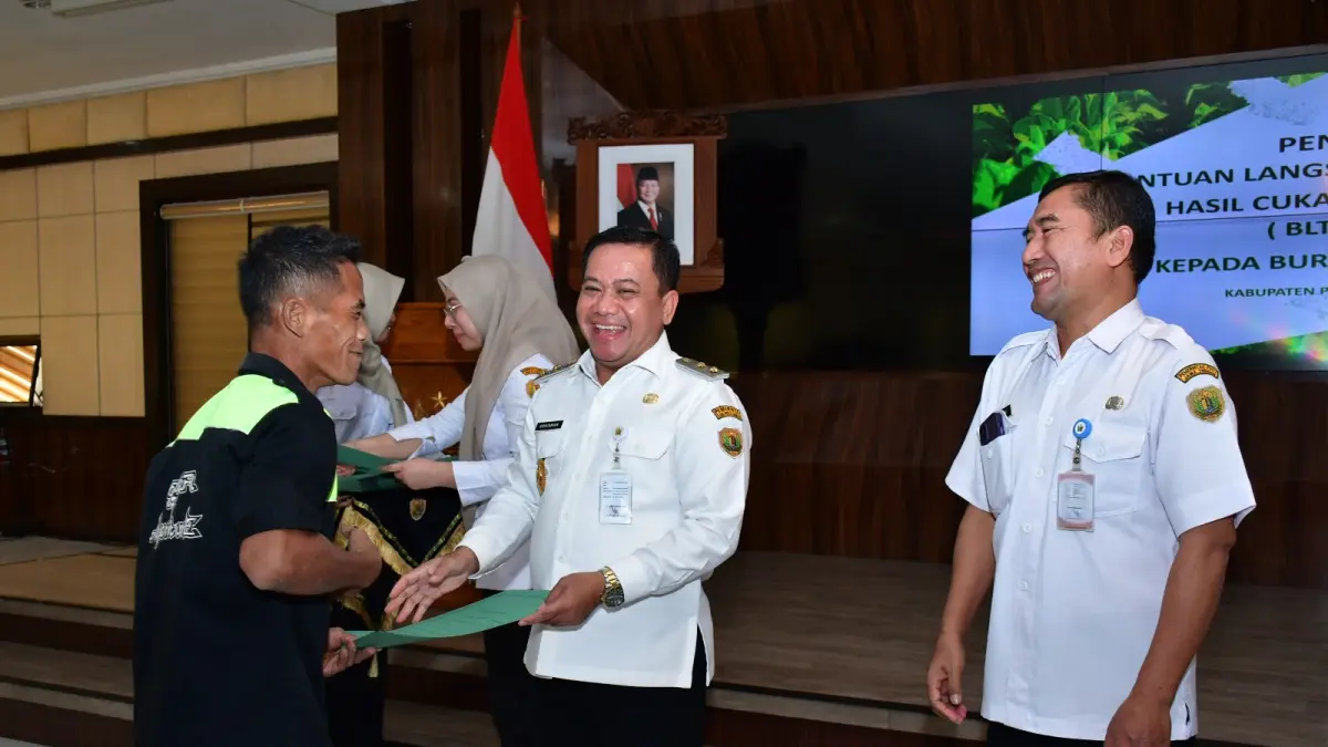 TAK DISANGKA: Plt. Bupati Pekalongan Sukirman saat menyerahkan BLT DBHCHT kepada petani yang juga bernama Sukirman. 