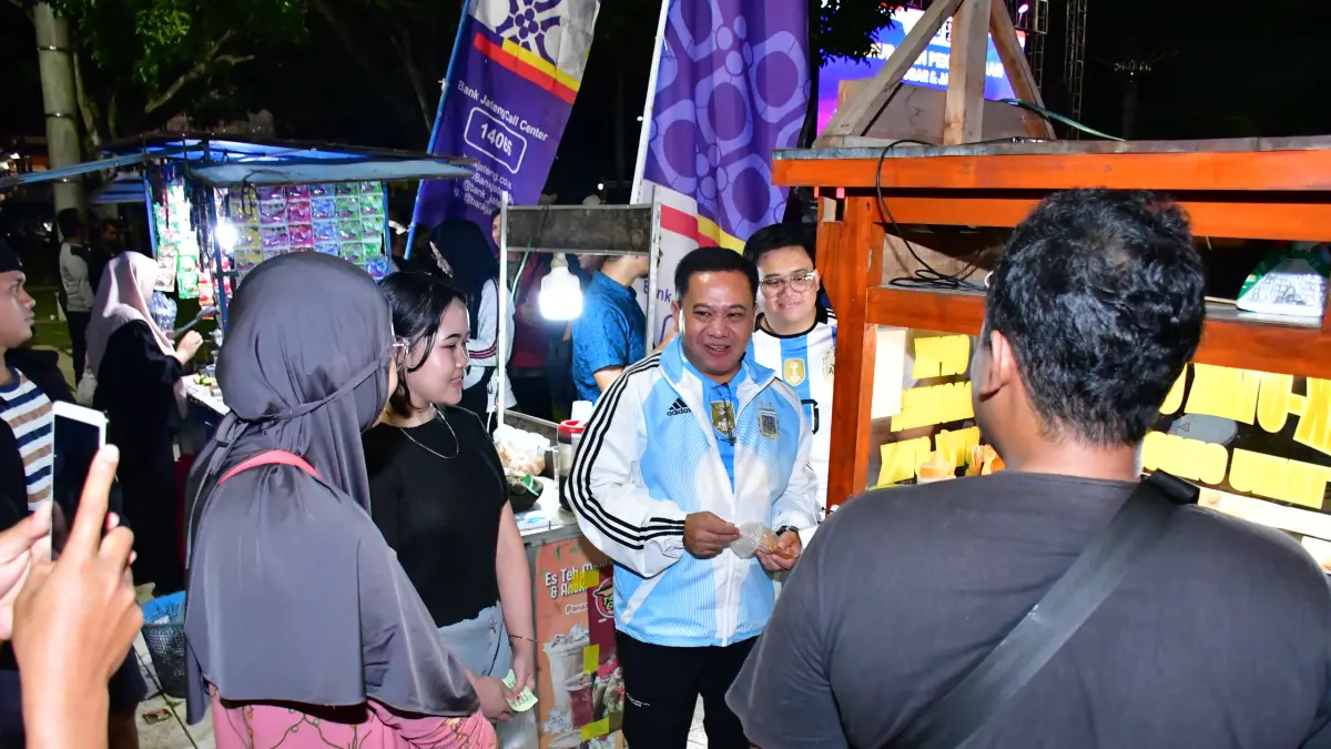 NOBAR: Plt. Bupati Pekalongan Sukirman saat menikmati jajanan di sekitar lokasi nobar Piala Dunia 2026 Argentina vs. Mesir, beberapa waktu lalu. (Dok. Prokompim Kabupaten Pekalongan)