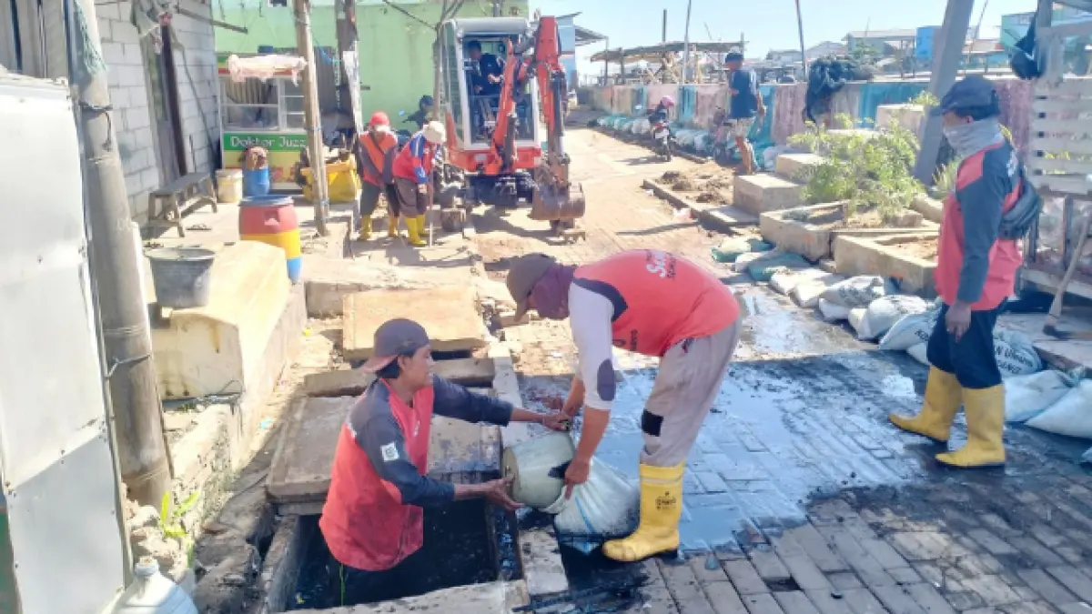 HAMBAT ALIRAN : Petugas DPU Kota Semarang membersihkan sampah dan sedimen yang menutupi saluran di Kawasan Tambak Mulyo, Semarang Utara. (FOTO: FIGUR RONGGO WASSALIM/JAWA POS RADAR SEMARANG&nbsp;