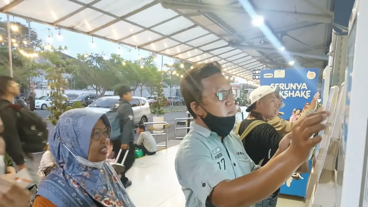 Petugas KAI Daop 4 Semarang membantu seorang lansia memesan tiket KA.