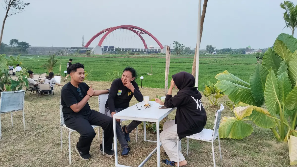 KOPI SENJA : Pengunjung saat menikmati kopi di Majiis Coffee Shop di Desa Mentosari, Kecamatan Gringsing, dengan latar megah Jembatan Merah Kalikuto.(Lutfi Hanafi/Jawa Pos Metro Pekalongan)